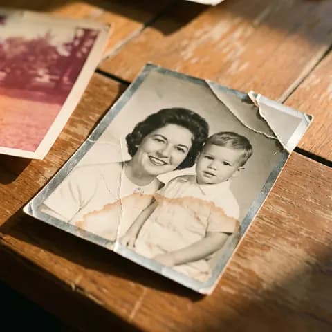 A creased, water-stained black-and-white portrait of a mother and child